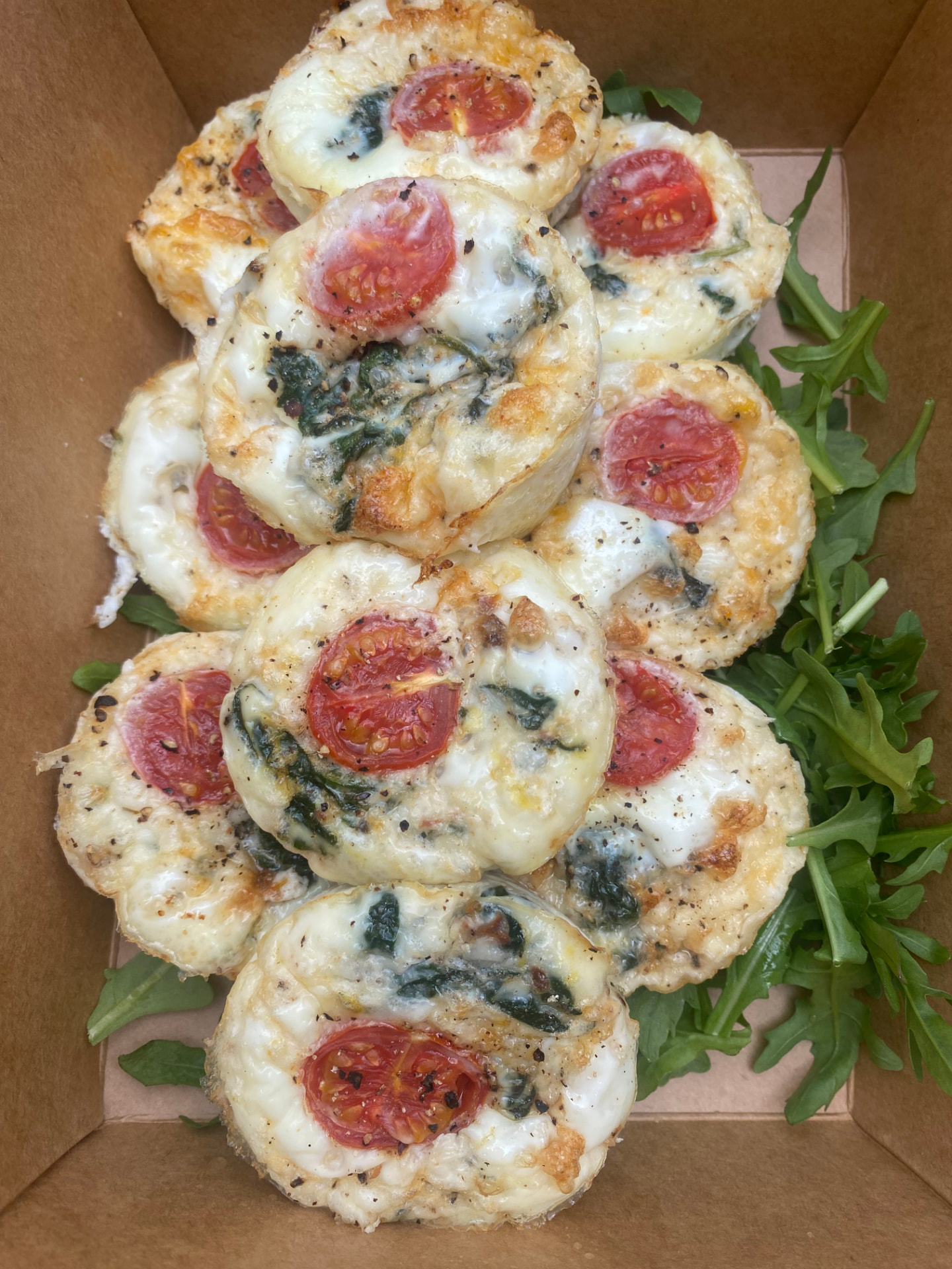 Baked egg muffins with spinach and tomato in a delivery box